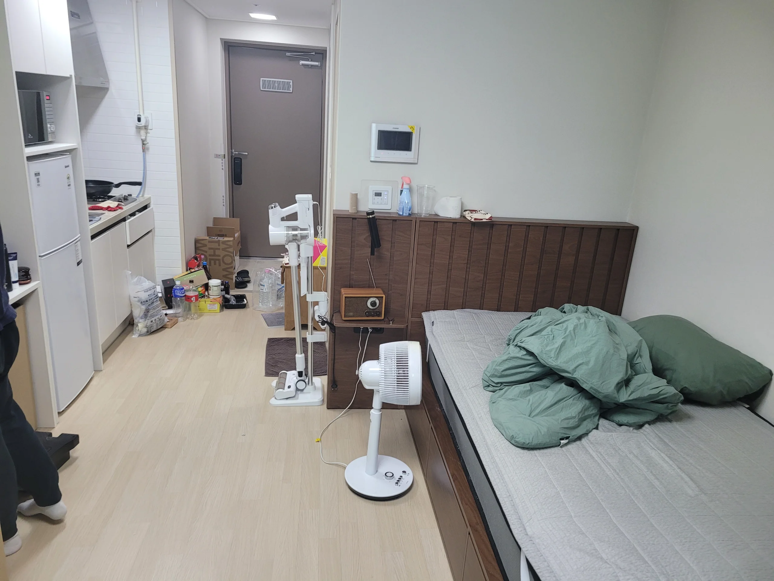 침대와 수납형 헤드보드가 놓인 원룸 내부 모습